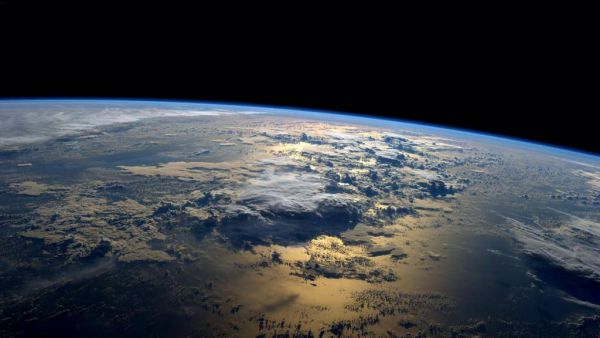 Солнце поднимается над Тихим океаном, освещая его. Фото сделано астронавтомРейдом Уайзманом 2 сентября 2014 года.